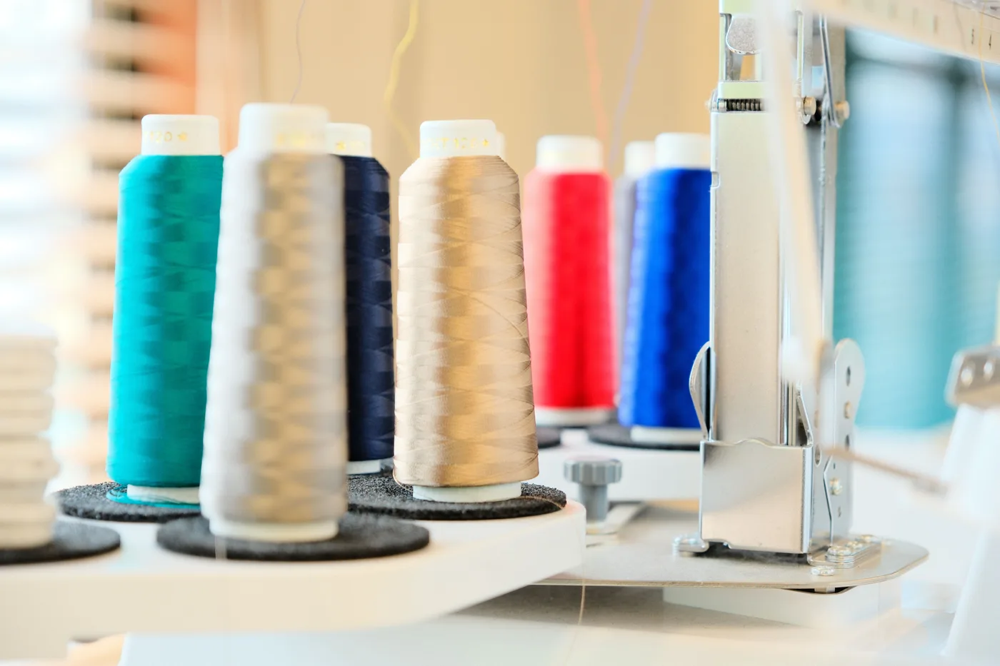 刺繍機にセットされた色とりどりの刺繍糸のコーン