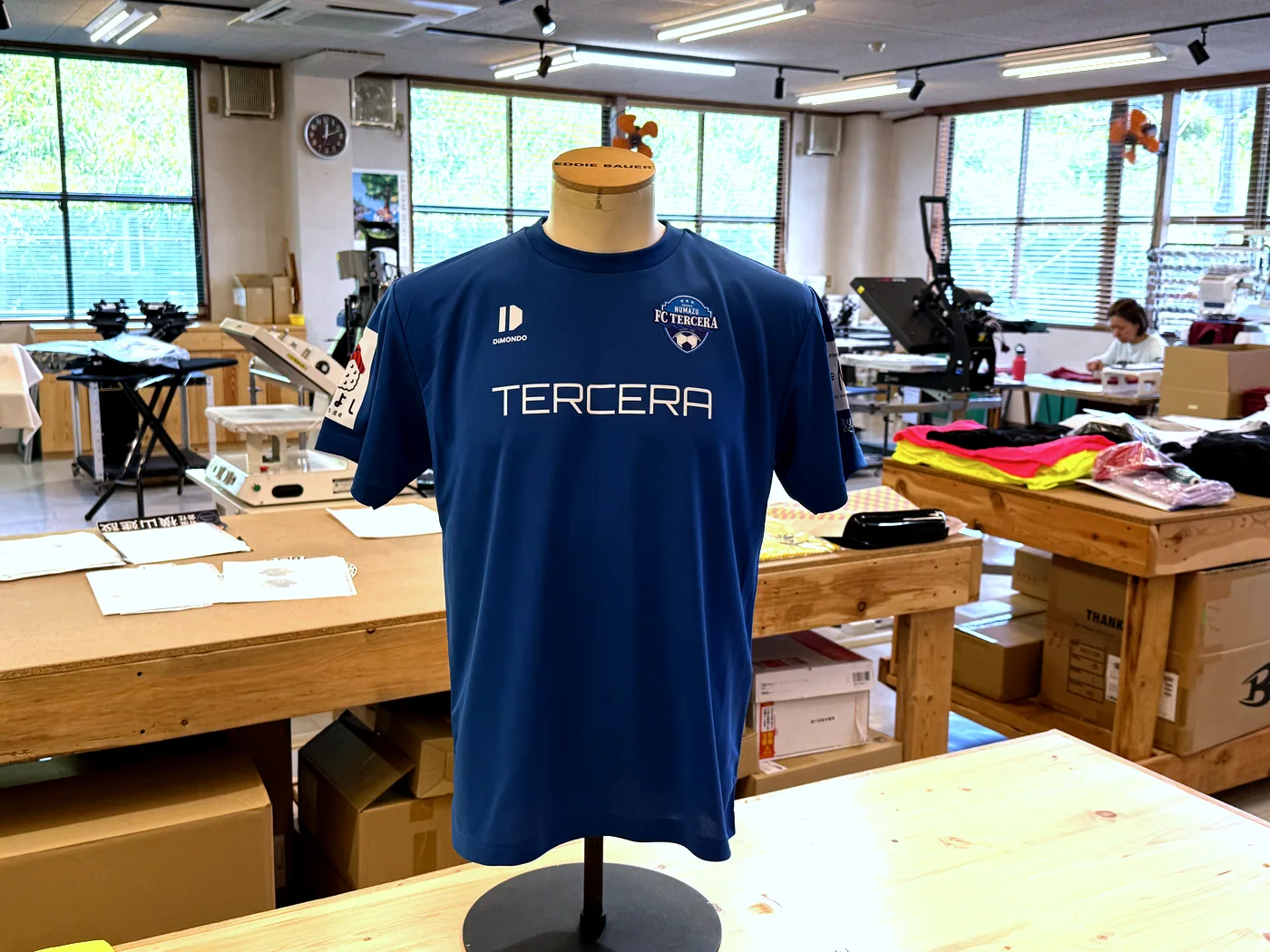 既製のドライTシャツにエンブレムとチーム名を入れたネイビーの練習着